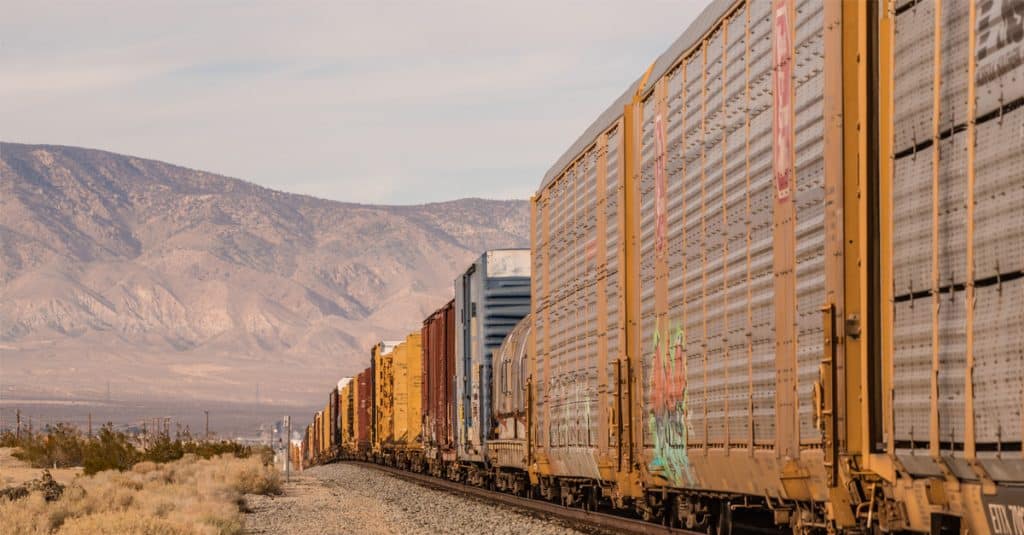 A long freight train in a mountainous desert.