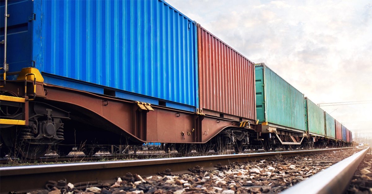 Line of colored rail freight cars stretching to the horizon.