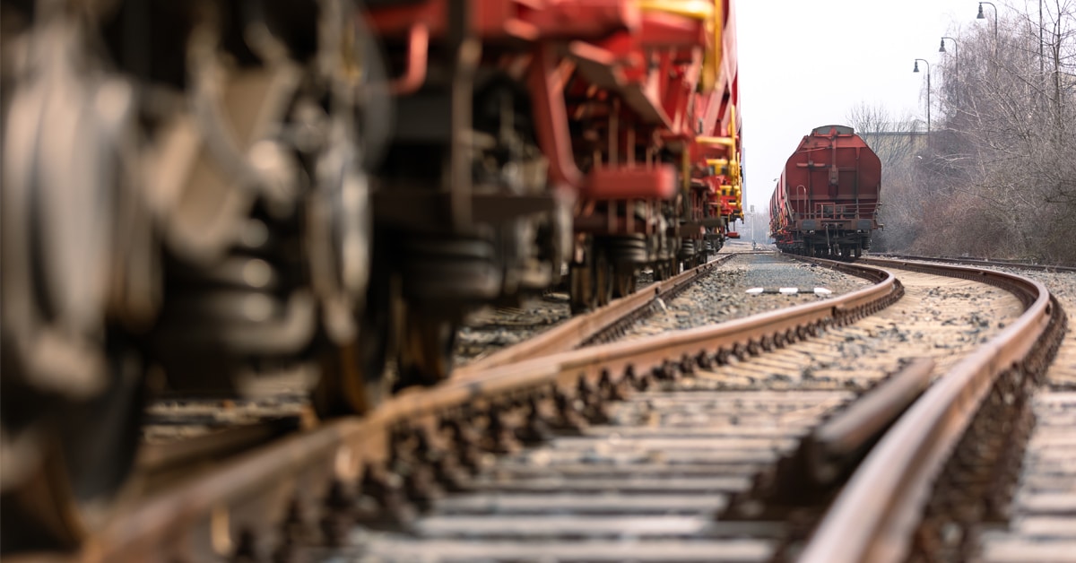 Red rail freight containers along a railroad track.