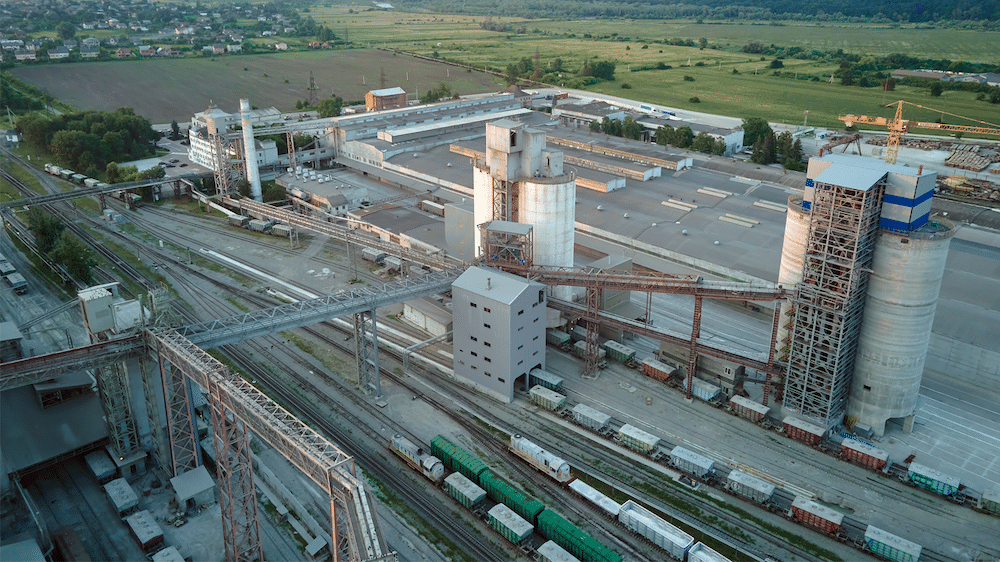 Aerial view of railway cargo train cars loaded with construction goods at a mining factory.