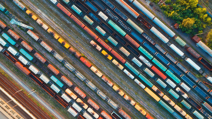 Aerial view of colorful freight trains with goods on many railroad tracks