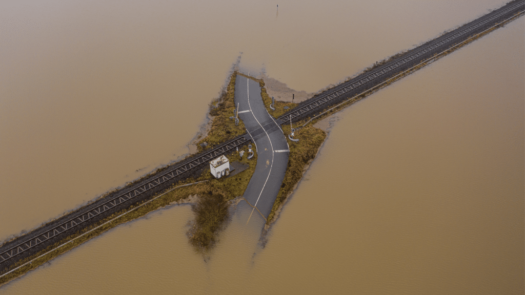 Railroad tracks above flooded, hurricane brown water.