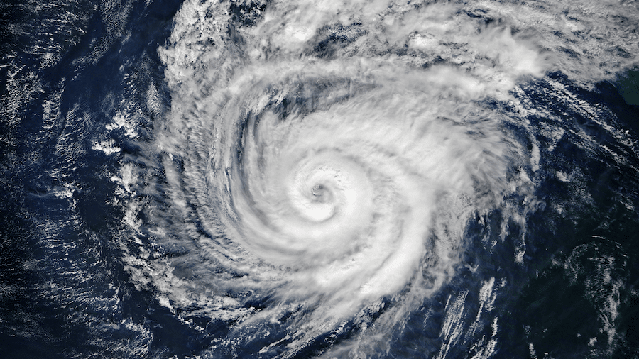 A tropical storm swirls over the ocean from a top-down perspective.